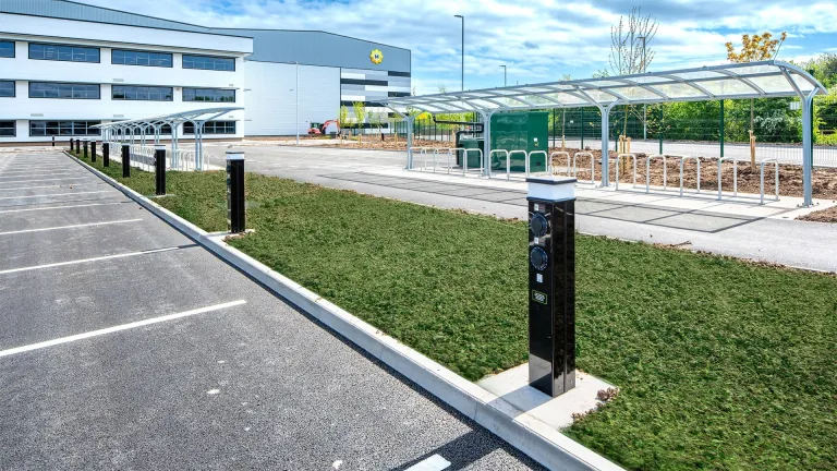 Car park with EV charging posts, landscaped verge and cycle shelter at XDock 549