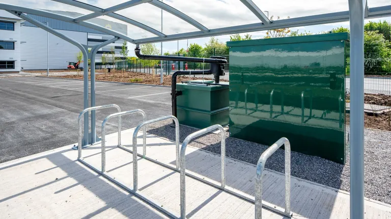 Covered cycle shelter with Sheffield stands next to the offices