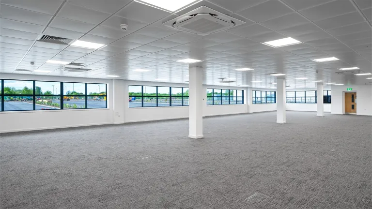 Open plan office floor with full height windows and air conditioning cassettes