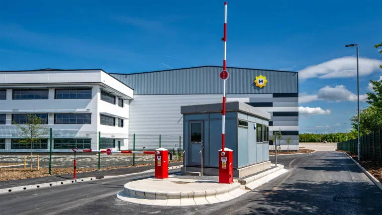 Security gatehouse and barrier at the XDock 549 entrance, with the offices behind
